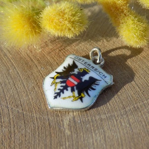 K&ouml;nnte beinhalten: Ein kleiner, schildf&ouml;rmiger Anh&auml;nger mit dem Wort "&Ouml;STERREICH" und dem &ouml;sterreichischen Wappen. Der Anh&auml;nger zeigt einen schwarzen Adler mit einem rot-wei&szlig;em Schild auf wei&szlig;em Grund, mit einer silberfarbenen &Ouml;se.