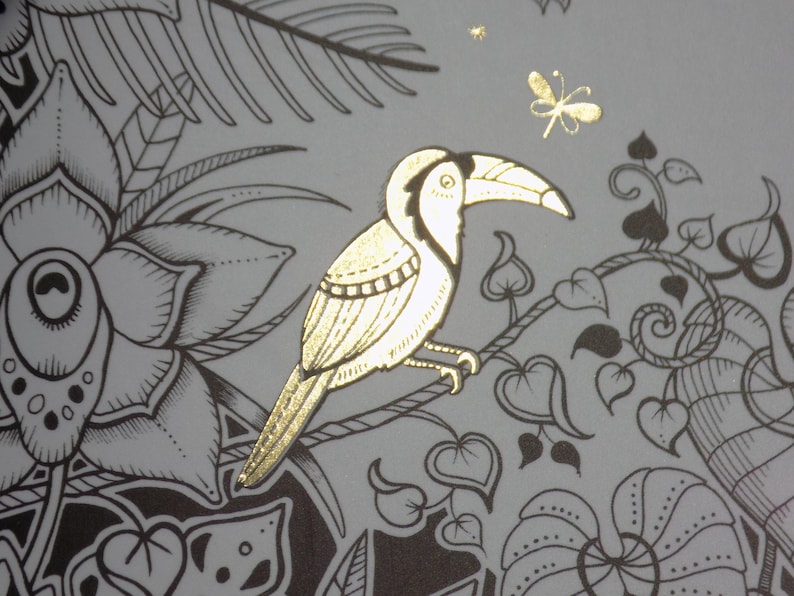 K&ouml;nnte beinhalten: Ein goldener Tukan mit langem Schnabel sitzt auf einem Ast mit schwarzen und wei&szlig;en Bl&auml;ttern. Der Tukan ist von einem floralen Design mit einer Libelle im Hintergrund umgeben.