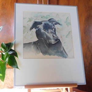 May include: Watercolor painting of a black dog's head and shoulders against a background of light green and white watercolor leaves.