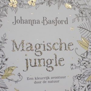 K&ouml;nnte beinhalten: Ein Buchcover mit wei&szlig;em Hintergrund und goldenen Folienakzenten. Der Titel lautet "Magische Jungle" von Johanna Basford. Der Text unter dem Titel lautet "Een kleurrijk avontuur door de natuur".