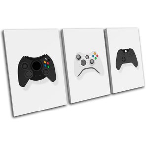 May include: Three canvas prints featuring different video game controllers. The leftmost print shows a black controller with colourful buttons. The middle print shows a white controller with colourful buttons. The rightmost print shows a black controller with a green button.