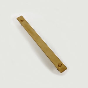 Peut inclure: Une barre métallique longue, fine et dorée avec deux vis hexagonales à chaque extrémité.