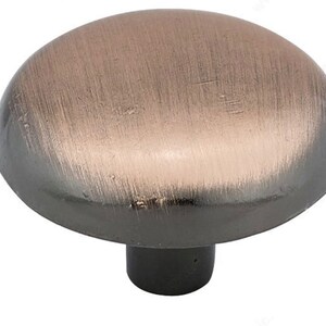 May include: A round, brushed copper cabinet knob with a black base.