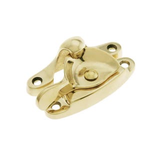 May include: A polished brass window latch with a rounded handle and a spring-loaded mechanism. The latch is designed to secure windows in an open position.
