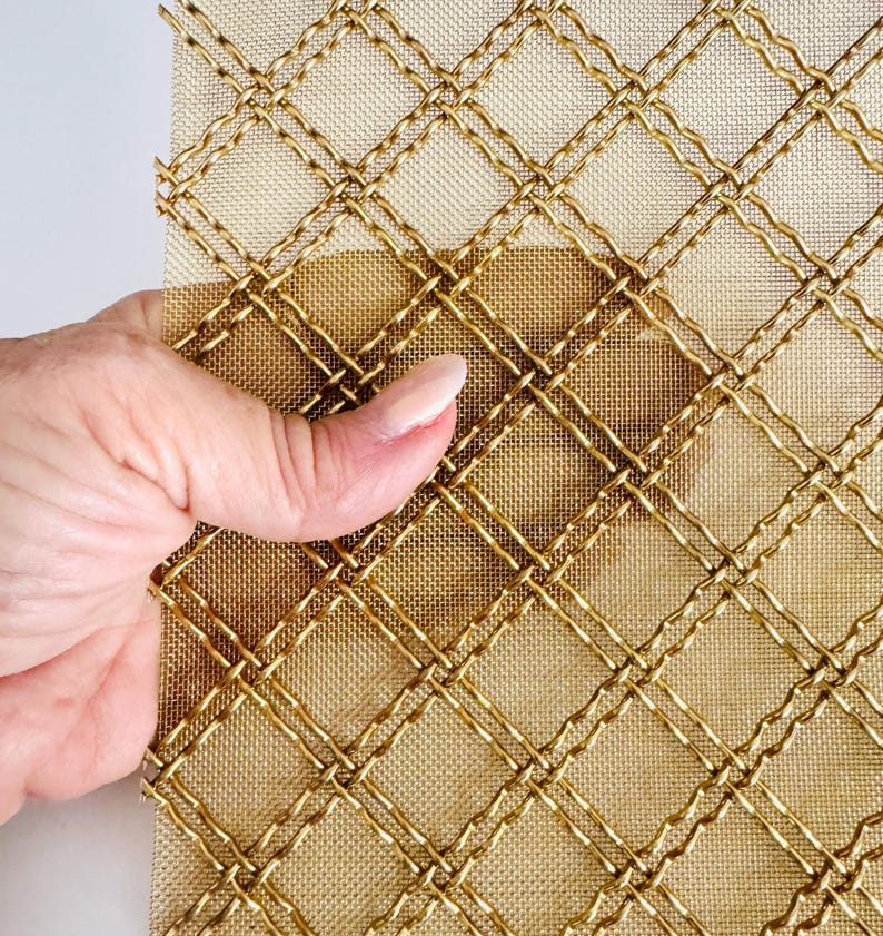 May include: Gold metal mesh with a diamond pattern. The mesh is flexible and has a woven texture.