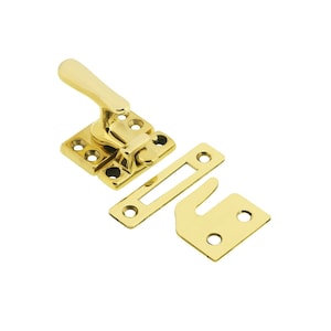 May include: Brass window sash lock with a lever handle and two separate plates. The lock is in a polished brass finish.