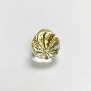 May include: A gold and clear glass cabinet knob with a swirl design.