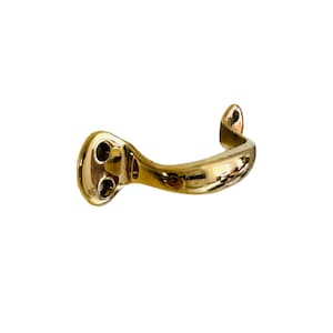 May include: A brass door handle with a curved design and two holes for mounting.