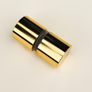 May include: Gold-toned metal door knob with a round shape and a smooth, polished finish.