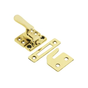 Könnte beinhalten: Fensterriegel aus Messing mit einem Hebelgriff und einer Schließplatte. Der Riegel ist so konzipiert, dass er ein Fenster in geöffneter Position sichert.