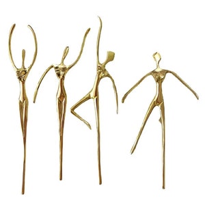 Puede incluir: Conjunto de cuatro esculturas de metal dorado de figuras abstractas. Las figuras son estilizadas y tienen un diseño minimalista.