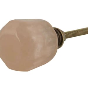 May include: A pale pink glass cabinet knob with a faceted design and a brass screw.