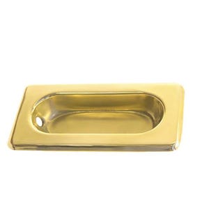 Puede incluir: Un tirador de puerta de armario de metal dorado con forma rectangular y una manija ovalada empotrada.