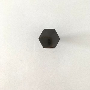 May include: A black hexagonal metal nut.