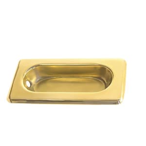 May include: A gold-toned rectangular cabinet door pull with a recessed oval handle.