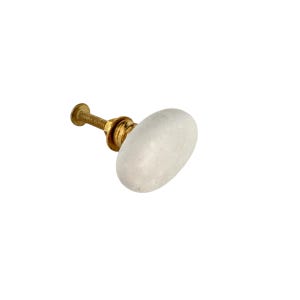 May include: A white, oval-shaped cabinet knob with a brass screw and base. The knob has a speckled appearance and is set against a white background. This hardware is suitable for drawers, cabinets, and furniture.