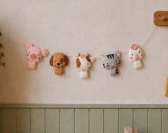 May include: A nursery scene with a garland of felt animal heads, including a pig, dog, cow, cat, and mushroom. A wooden chair with a heart-shaped back, a bookshelf, and a storage bench with wicker baskets are also visible. A yellow cardigan hangs on a wooden rack.