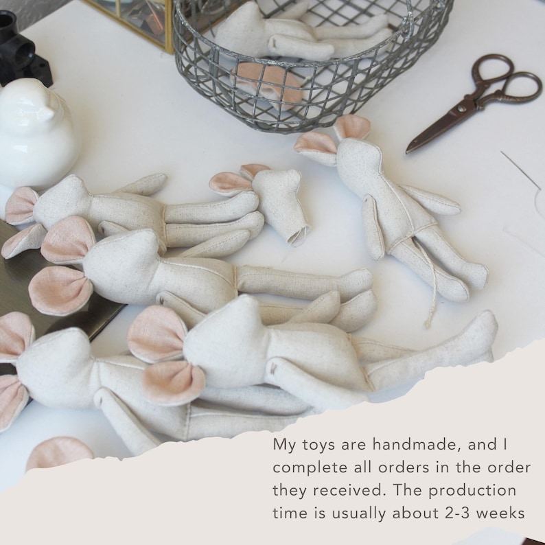 May include: Handmade fabric mouse toys in various stages of completion, with pink ears and a light beige body. Some mice are lying down, while others are in a wire basket. A pair of scissors and text are also visible.