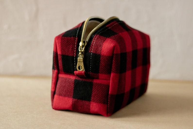 Red and black buffalo plaid pattern with antique bronze zipper track and pull.