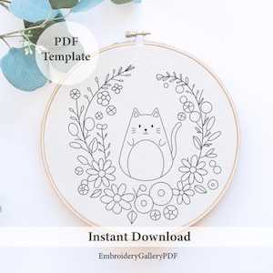 May include: Black and white line art embroidery pattern of a cat sitting in a wreath of flowers. The pattern is on a white background and is labeled "PDF Template" and "Instant Download".