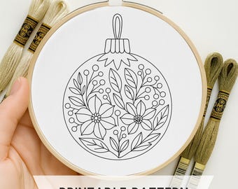 Könnte beinhalten: Ein weißer Stickrahmen mit einem schwarz-weißen floralen Ornamentdesign. Der Text "PRINTABLE PATTERN" wird auf einem weißen Banner angezeigt. Mehrere Spulen Stickgarn sind sichtbar.