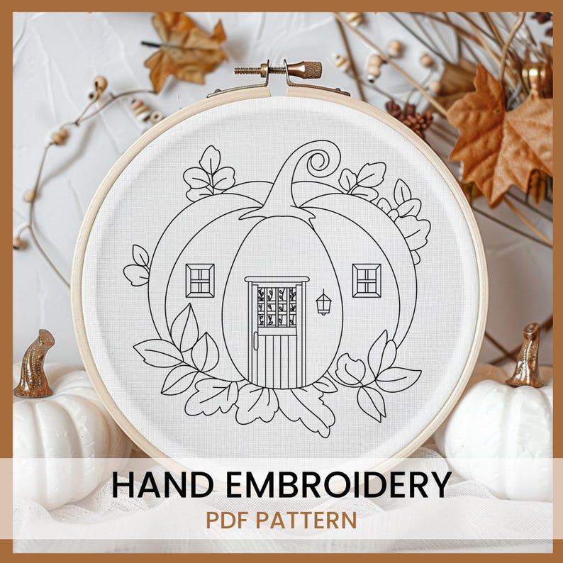 May include: A black and white line drawing of a pumpkin shaped house with a door and windows. The pumpkin is surrounded by leaves. The image is in a round embroidery hoop. "HAND EMBROIDERY PDF PATTERN" is written below the hoop.