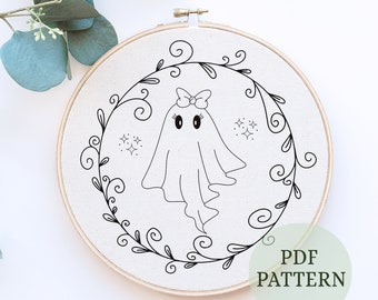 May include: A black and white embroidery hoop featuring a cute ghost design with a bow, surrounded by a floral wreath. The text "PDF PATTERN" is visible. This craft project is perfect for Halloween or spooky-themed decor.