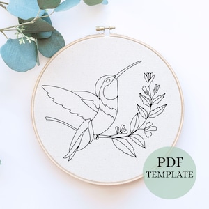 May include: A black and white line drawing of a hummingbird perched on a branch with flowers. The image is on a white background and is in a wooden embroidery hoop. The text "PDF TEMPLATE" is in the lower right corner of the image.