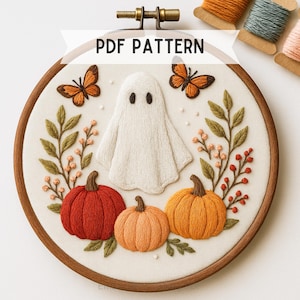 May include: Embroidered Halloween hoop art with a white ghost, orange pumpkins, and butterflies. The design includes the text "PDF PATTERN". The embroidery is set in a wooden hoop.