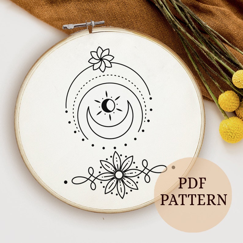 May include: A black and white embroidery pattern featuring a sun, moon, and flower design. The pattern is displayed on a white embroidery hoop. The text "PDF PATTERN" is visible in the lower right corner of the image.
