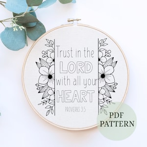 Puede incluir: Aro de bordado en blanco y negro con el texto "Trust in the LORD with all your HEART" y "PROVERBS 3:5". El aro está rodeado por un diseño floral.