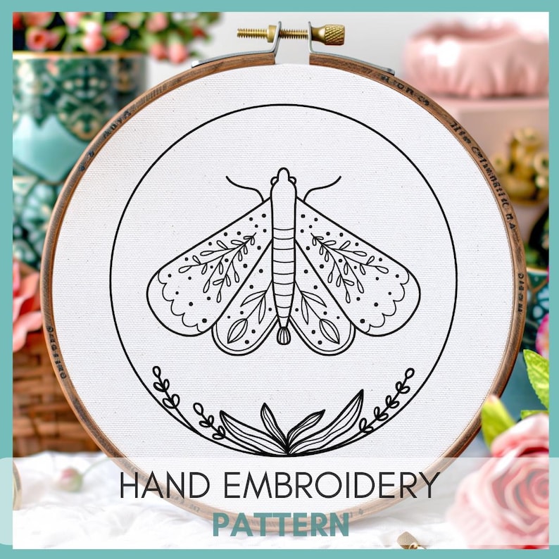 Peut inclure: Motif de broderie noir et blanc d'un papillon de nuit avec des d&eacute;tails floraux sur un tissu blanc dans un cerceau de broderie en bois. Le cerceau a une &eacute;chelle de mesure imprim&eacute;e en noir et blanc. Le texte "HAND EMBROIDERY PATTERN" est imprim&eacute; sous le cerceau.