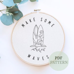 Könnte beinhalten: Ein cremefarbener Stickrahmen mit den Worten "MAKE SOME WAVES" und zwei Surfbrettern in schwarzer Strichzeichnung. Die Surfbretter haben dekorative Designs. Ein grünes PDF-Muster-Etikett befindet sich unten rechts.