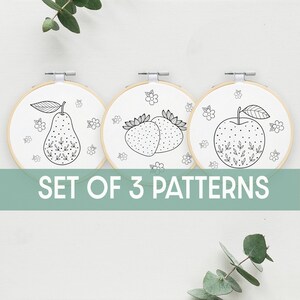 May include: Set of three embroidery patterns featuring a pear, strawberries, and an apple. Each pattern is surrounded by small flowers and leaves.