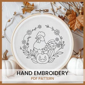 May include: Black and white line art embroidery pattern of a rooster with a pumpkin in a wreath of flowers. The pattern is in a hoop on a white background.  Hand Embroidery PDF Pattern.