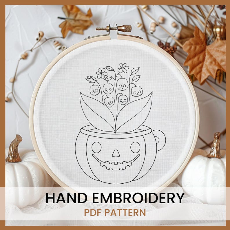 May include: A black and white line drawing of a pumpkin with a smiling face and a bouquet of flowers with skulls in the center. The image is in a hoop and is labeled "HAND EMBROIDERY PDF PATTERN".