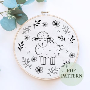 Pode incluir: Padrão de bordado preto e branco de uma ovelha com flores e folhas. O padrão está sobre um fundo branco e está pronto para ser bordado. PADRÃO PDF.
