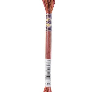 May include: A single skein of embroidery floss in shades of orange, brown, and pink. The label reads "DMC" and includes a barcode and the number "4130". The thread is tightly wound at both ends and in the middle.