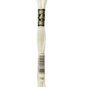 Peut inclure: Une bobine de fil à broder DMC de couleur 746, un blanc crème. Le fil est enroulé sur une bobine en carton avec une étiquette noire et dorée qui indique "DMC Mouliné Special 25 8 m (8,7 yds)".