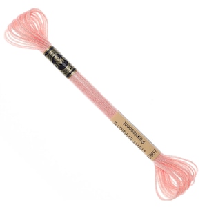 Puede incluir: Una bobina de hilo de bordar rosa claro con una etiqueta que dice "Light Effects 769 Pearlescent".