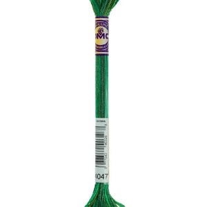 Puede incluir: Madeja de hilo de bordar verde con una etiqueta morada y dorada. El hilo es una mezcla de tonos verdes oscuros y claros, con el número 4047 visible. Ideal para punto de cruz y bordado.