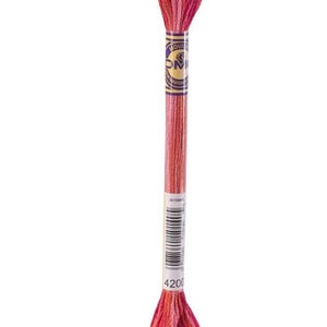May include: A single skein of embroidery floss in shades of red and pink. The floss is wrapped around a cardboard label with the brand name and a product number. The color is a gradient from light to dark, with the number 4200 visible.