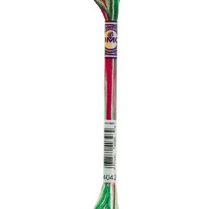 May include: A skein of DMC embroidery floss in shades of red, green, and white. The floss is wrapped and labeled with the number 4042. The top of the skein is a mix of green, red, and white threads.