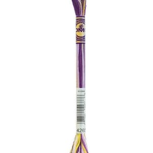 May include: A single skein of embroidery floss in shades of purple, yellow, and white. The floss is wrapped with a paper label that includes the brand name and a barcode. The color number "4265" is visible on the label.