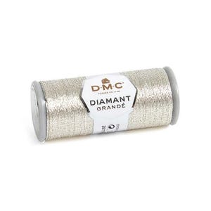 Puede incluir: Una bobina de hilo metálico DMC Diamant Grandé plateado, etiquetada G168 - estaño. El hilo está enrollado en una bobina cilíndrica con tapas de extremo gris y una etiqueta blanca con el logotipo de DMC e información del producto.