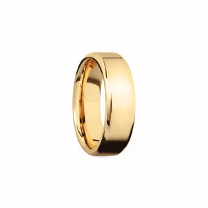 Op de afbeelding: Een gouden trouwring met een gepolijste afwerking. De ring heeft een afgerond, gewelfd profiel en een glad, reflecterend oppervlak. De band is een klassiek ontwerp, geschikt voor dagelijks gebruik.