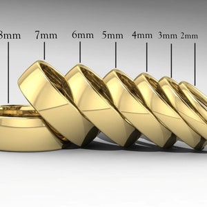 Può includere: Un set di sette fedi nuziali in oro di diverse larghezze, che vanno da 2 mm a 8 mm. Le fedi sono impilate l'una sull'altra, con la più larga in basso e la più stretta in alto. Le fedi sono tutte in oro 10 carati.