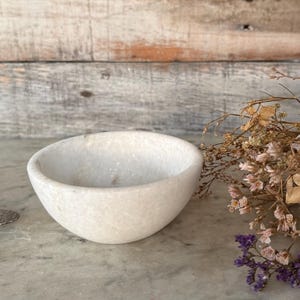 May include: A set of three ceramic mugs with a speckled, matte finish. The mugs are in shades of cream, light gray, and dark gray. Each mug has a simple, minimalist design, perfect for coffee or tea.