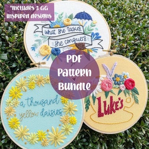 May include: Three embroidery hoop patterns with floral designs. The top hoop features a blue umbrella and the text "What she tackles, she conquers". The middle hoop features a blue background with yellow daisies and the text "a thousand yellow daisies". The bottom hoop features a yellow background with a cup of coffee and the text "Luke's".