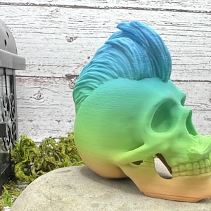 May include: A green, blue, and yellow gradient skull with a mohawk hair style. The skull is made of plastic and is a decorative item.